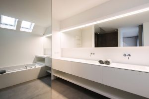 afbeelding van de badkamer met het bad in de reflectie van de spiegel