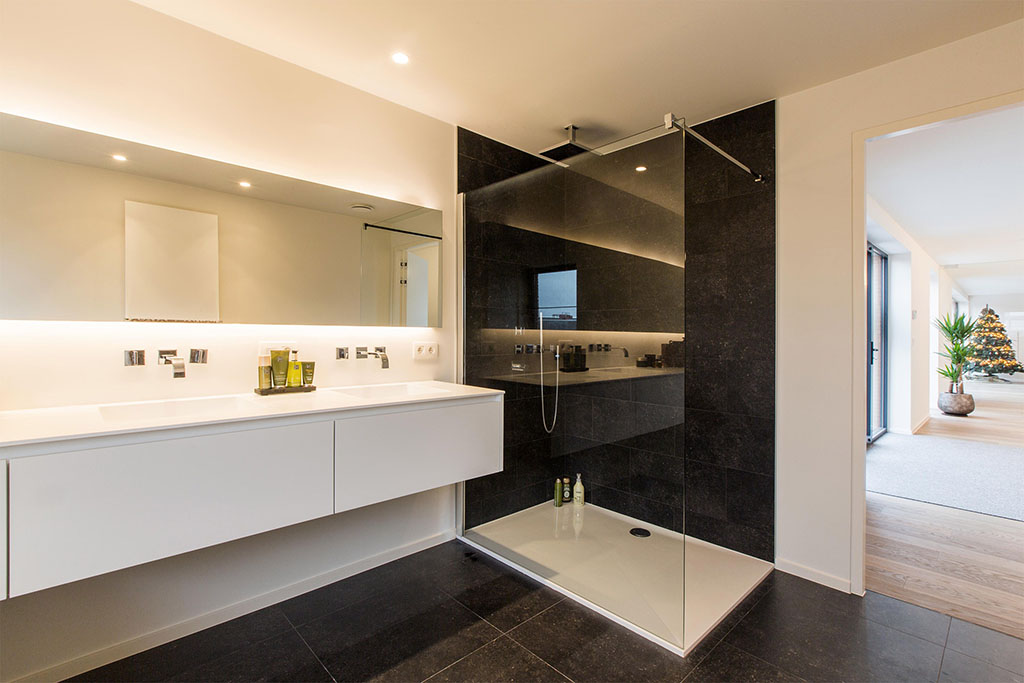badkamer met een luxe douchecabine en zwarte tegels