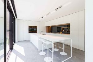 tijdloze witte keuken met vier moderne krukken aan het keukenblad