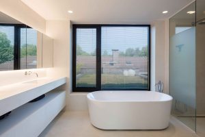 badkamer met een ovaal bad en raamdecoratie