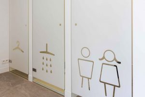 witglazen deuren met iconen voor kleding, douche en toilet man of vrouw